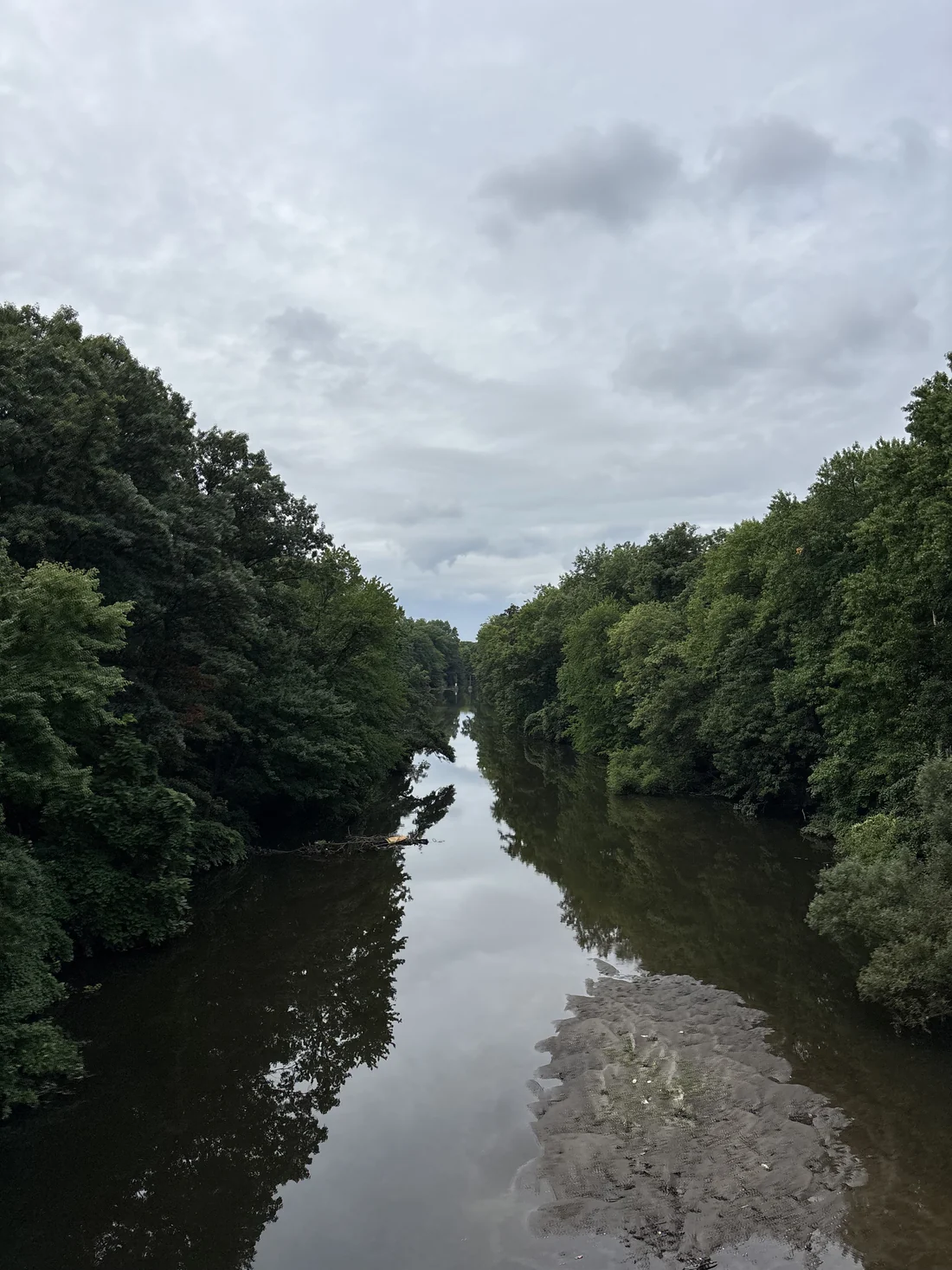 Quiet river reflecting the trees along its banks